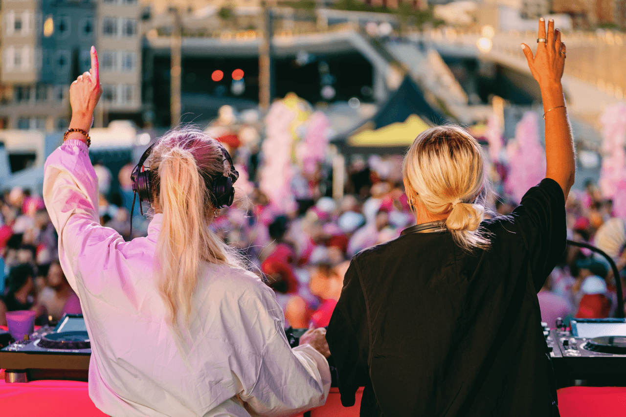 Two DJs perform to a crowd