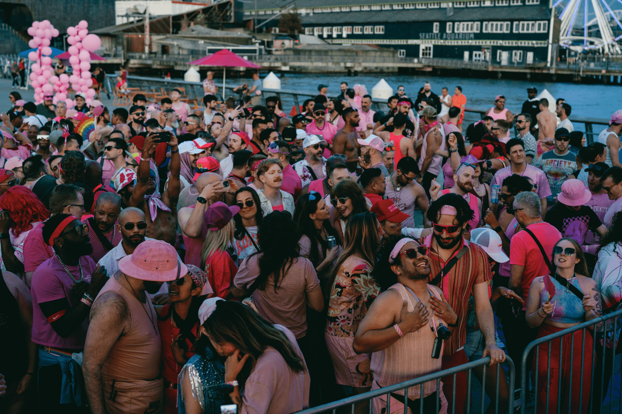 Crowd of people dancing to music at sunset the waterfront in Seattle.